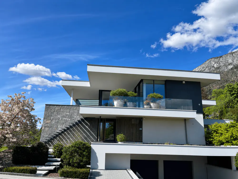 Villa contemporaine en pierre et enduit blanc à Talloires — visuel Invest Prestige